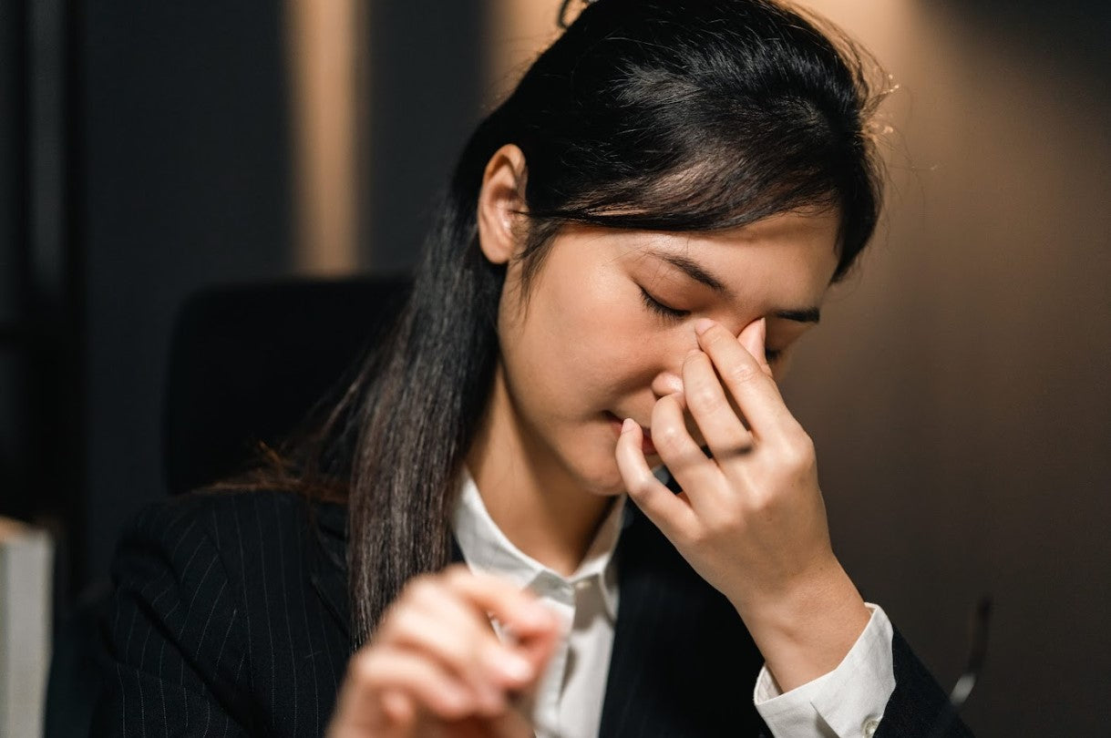 Asian woman applying gentle pressure to the inner eye region to relieve eye strain and blurry vision